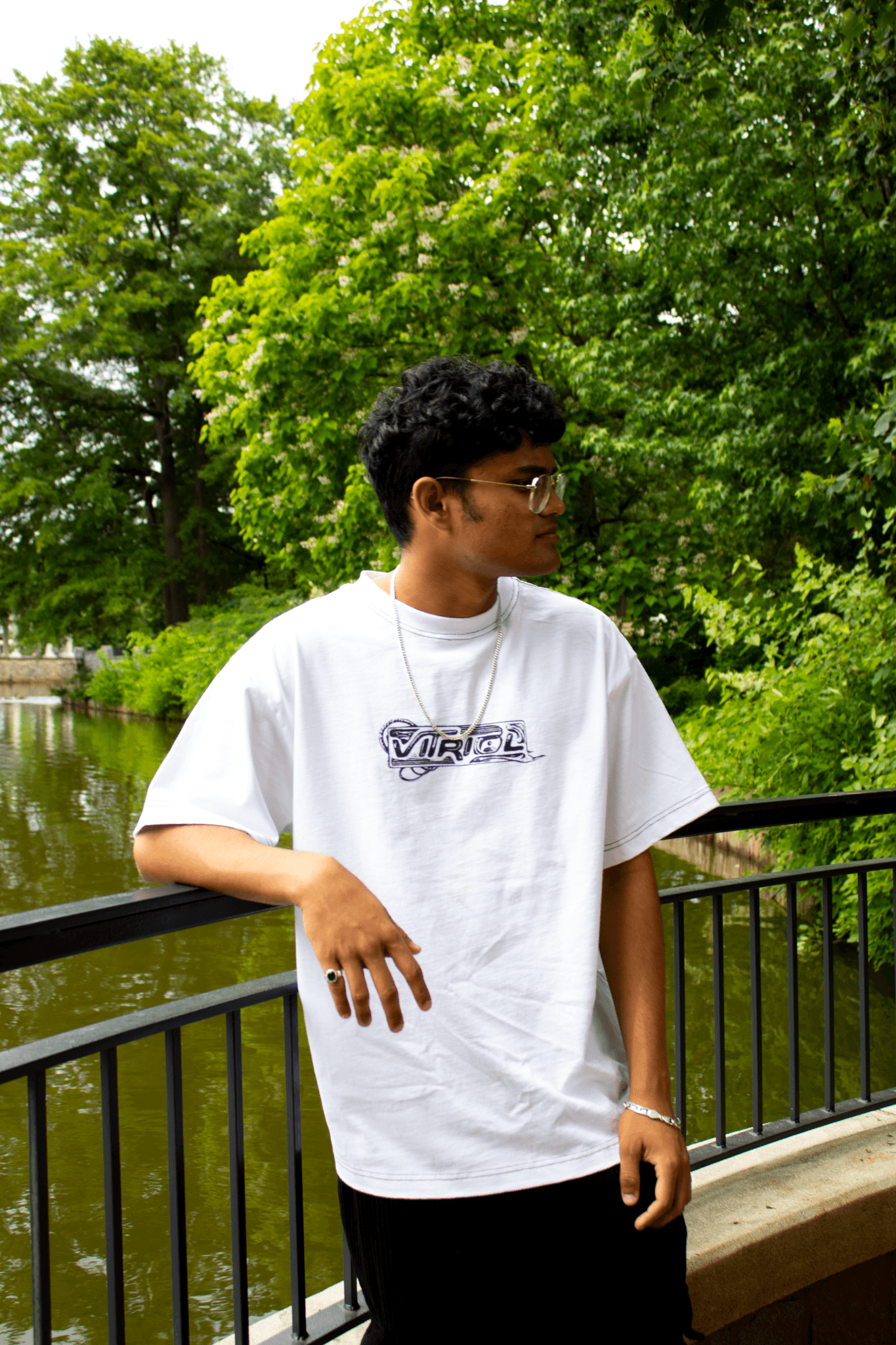 Ayush Basu by a river bridge