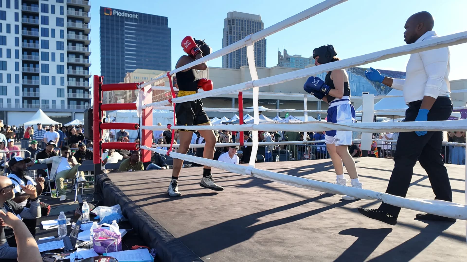 Two fighters in an outdoor ring with the Atlanta skyline behind